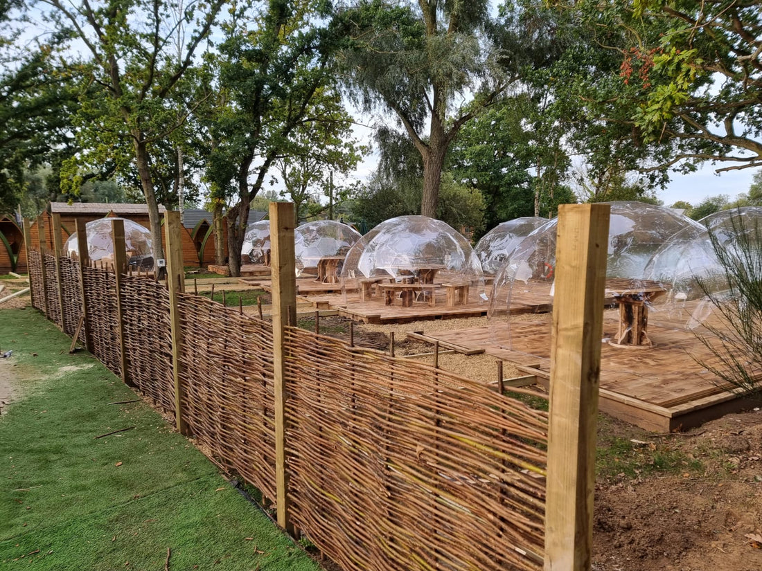A row of GeoDomeX domes on wooden decking at a hospitality site